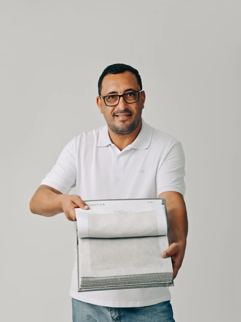 Alessandro, da CORA, mostrando um mostruário de tecidos