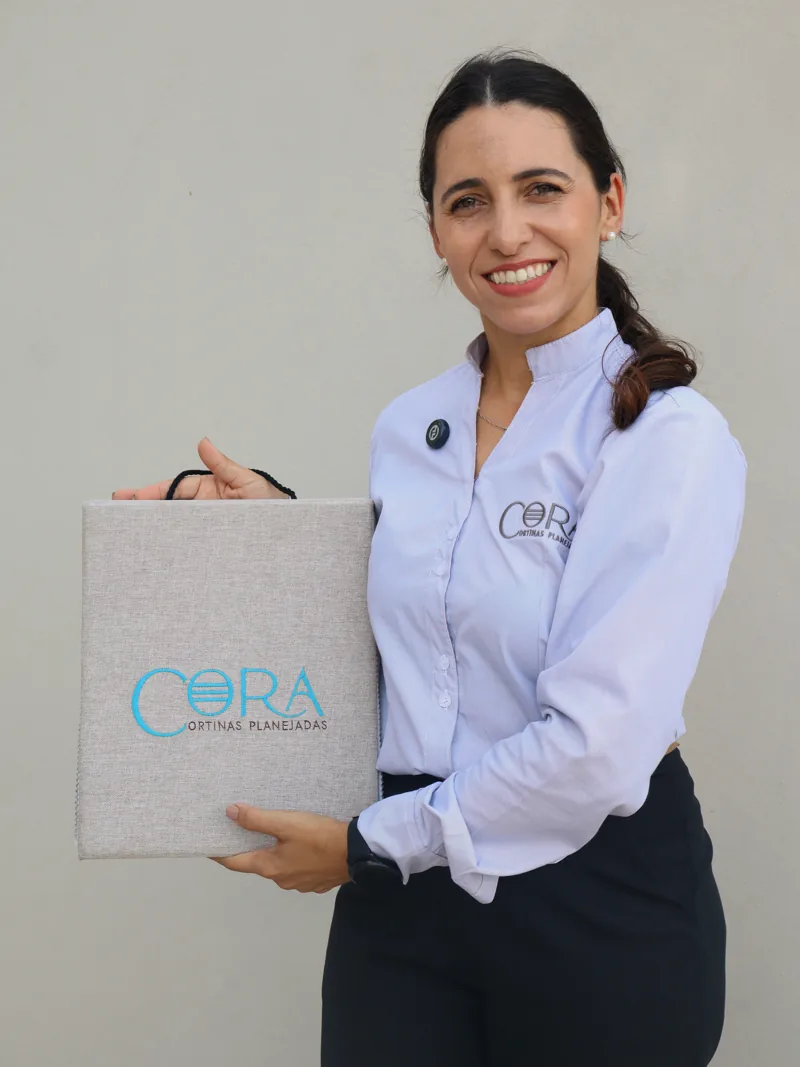 Fernanda, da CORA, com o mostruário de tecidos da CORA nas mãos